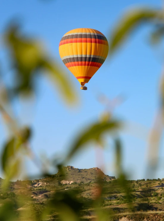 an image of a  air balloon flying over a hill