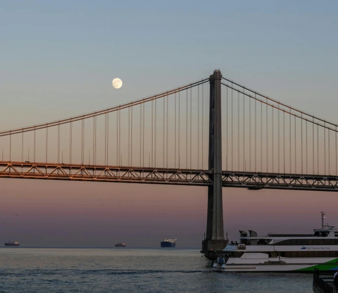 a view of a bridge with boats and ships in the background