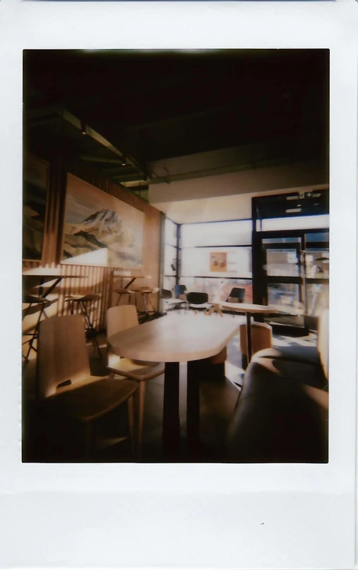 an old po of a table and chairs with pictures on the wall behind