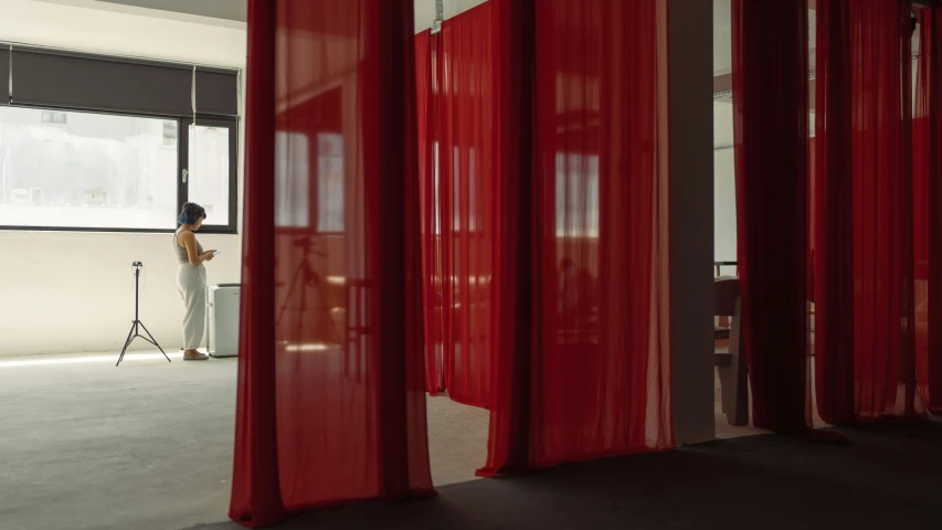 a man standing in front of a window looking at his phone