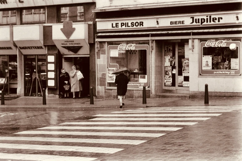 people walking through a crosswalk in front of a store