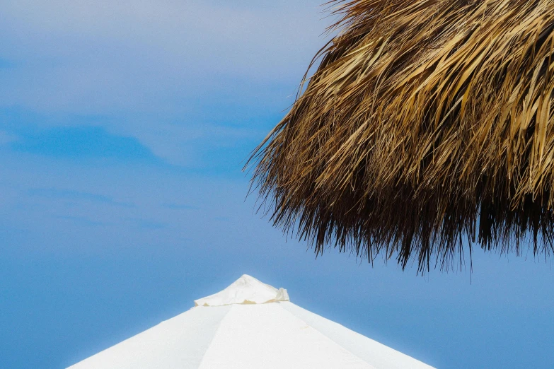 a white beach umbrella on the side of a building