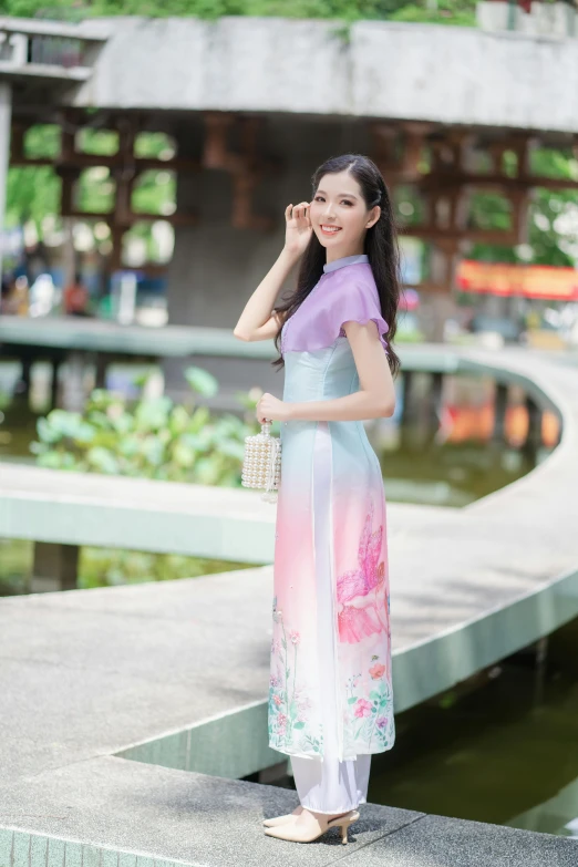 a woman standing next to water wearing a dress