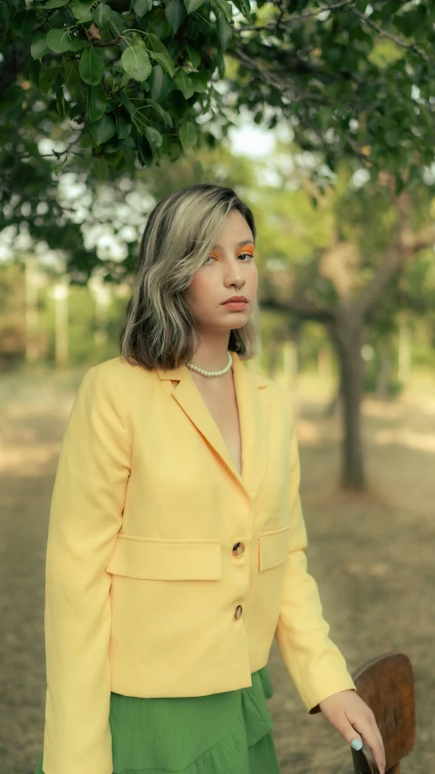 a woman with long grey hair in a yellow jacket