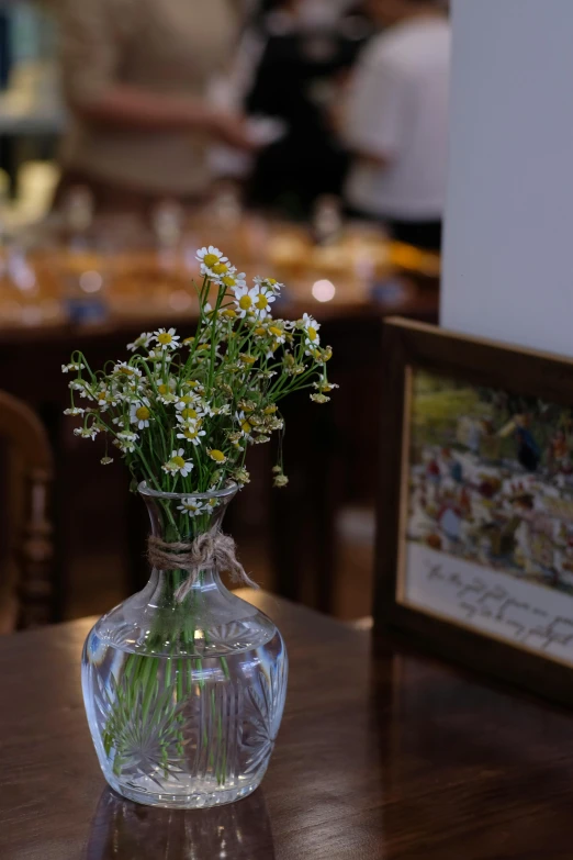 a clear vase filled with lots of yellow flowers