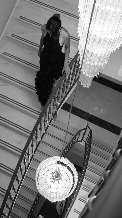 a woman walking down a spiral staircase with an umbrella