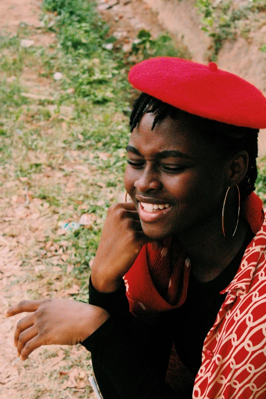 a person in an orange shirt and a red cap on a phone