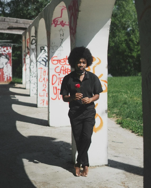 a woman standing next to several graffiti covered wall