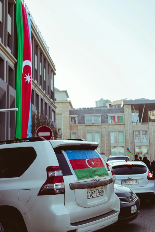 cars with the flags of different countries parked in front of a building