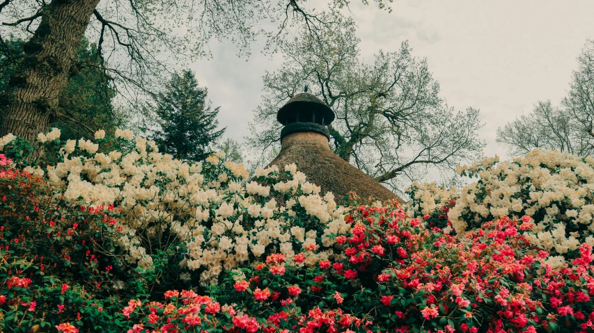 a statue of a man in a cap surrounded by flowers