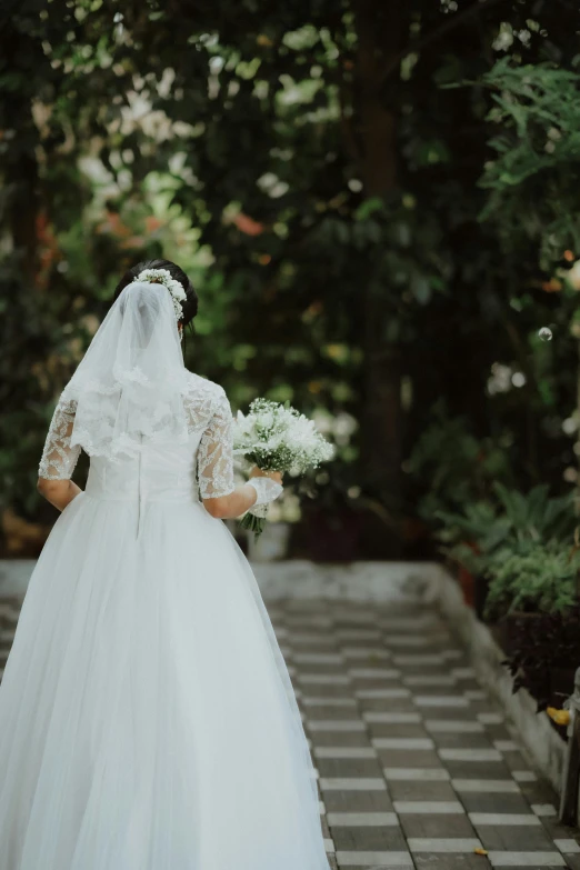 a bride in a white dress carrying a bouquet