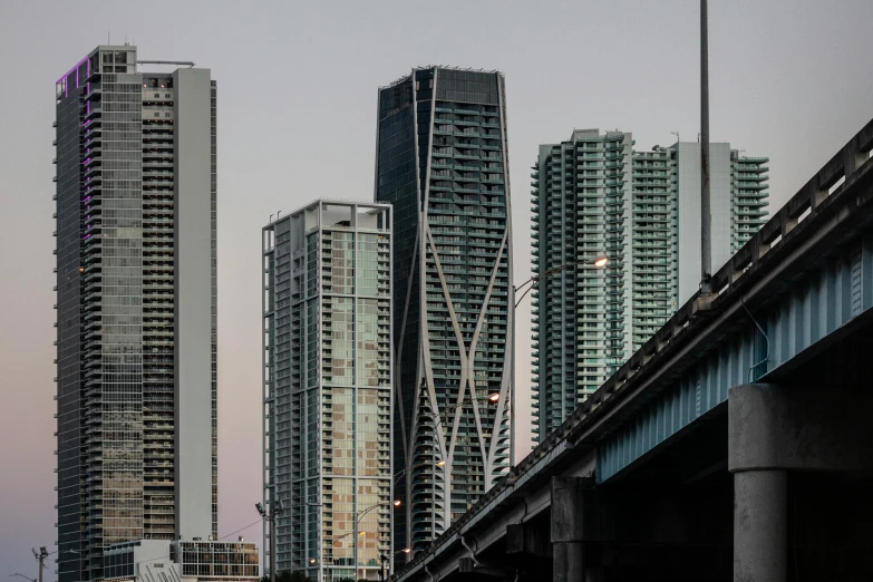 a tall city has tall skyscrs and cars parked