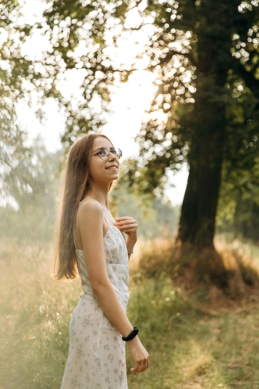 a woman wearing a dress standing in the woods