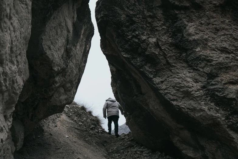 a person walking up a narrow path between large rocks