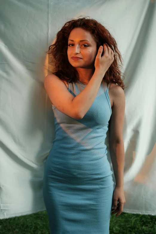 the woman in a blue dress poses for a portrait