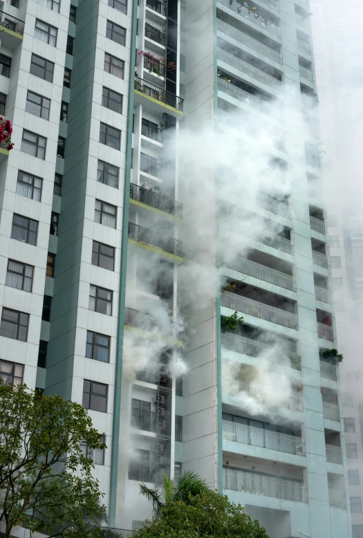 the building has several balconies with green plants growing on it