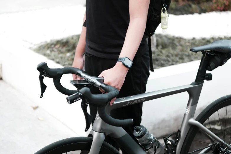 a man standing with his bike in front of some bushes