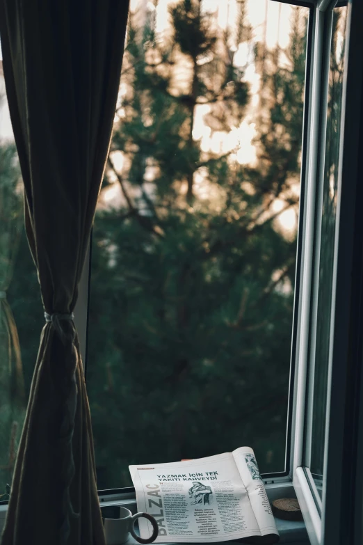 a window with a curtain and a note sitting next to it