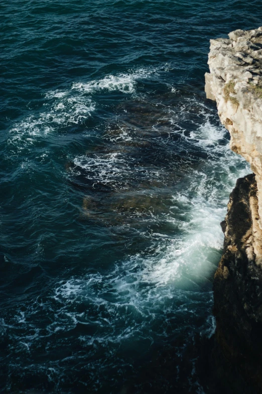 the side of a cliff that looks out into a body of water