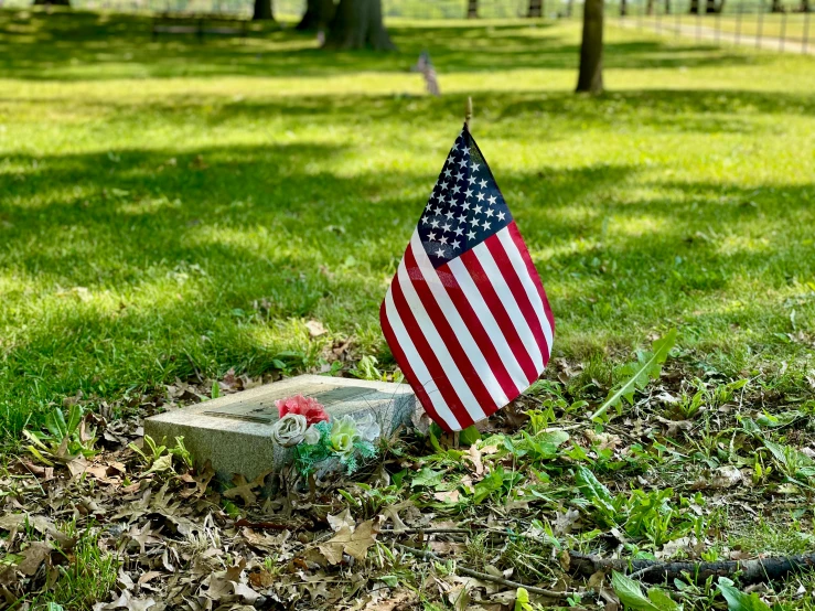 an american flag sits on the ground next to a memorial