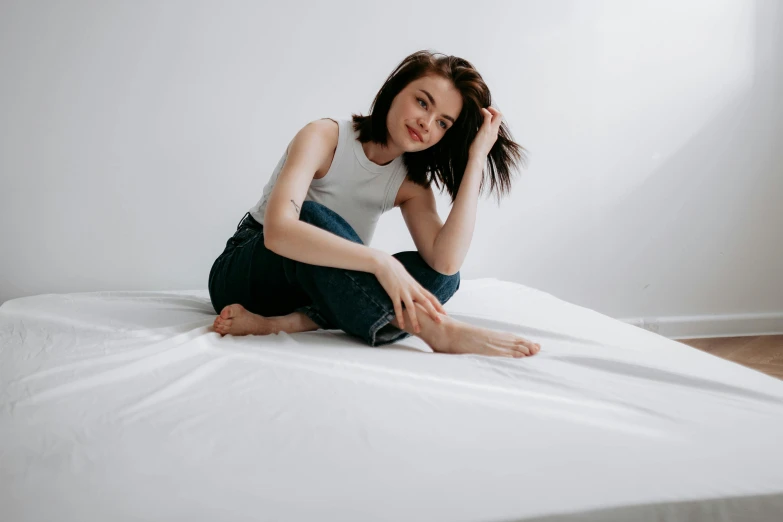 a young woman is posing on her bed