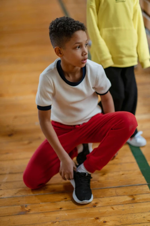 there is a boy playing with a frisbee in a gym