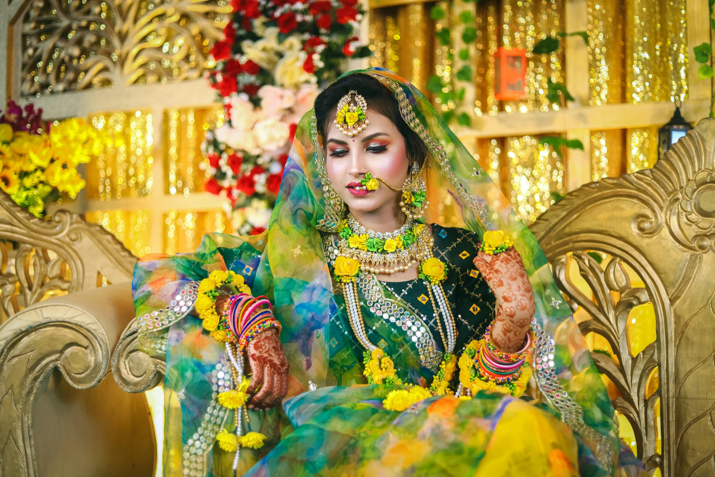 a woman in a indian wedding outfit sitting on a gold chair