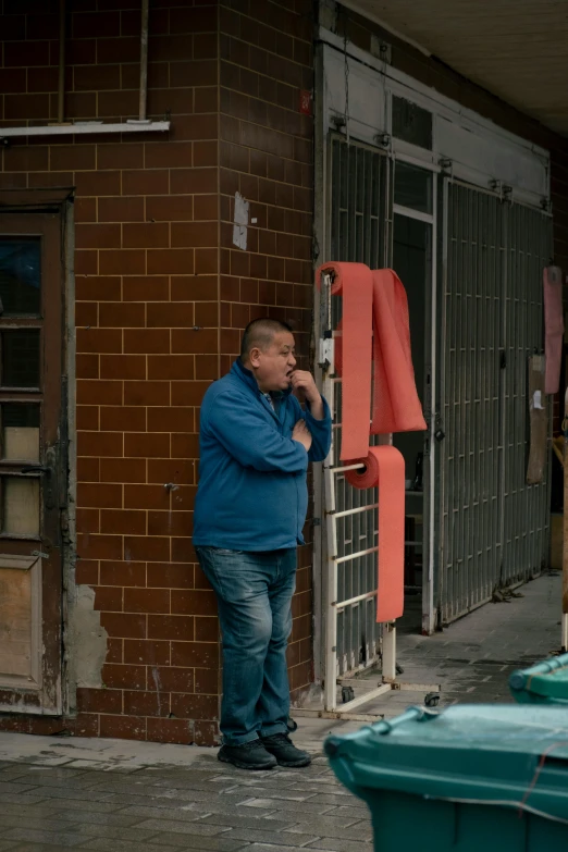 a man stands near an open window on a brick building