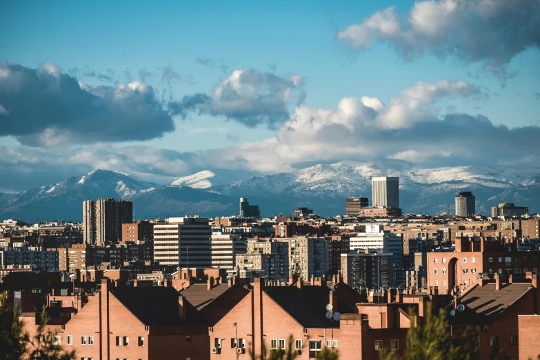 a beautiful view of some buildings and snow covered mountains