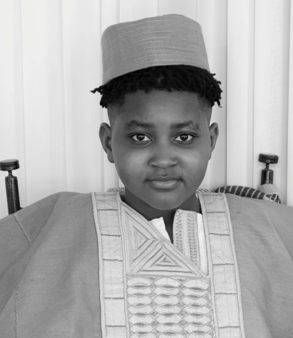 a young man poses for a po in traditional clothing