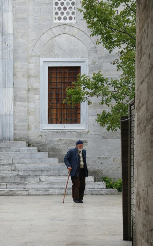 a man walking outside of a building on a sidewalk