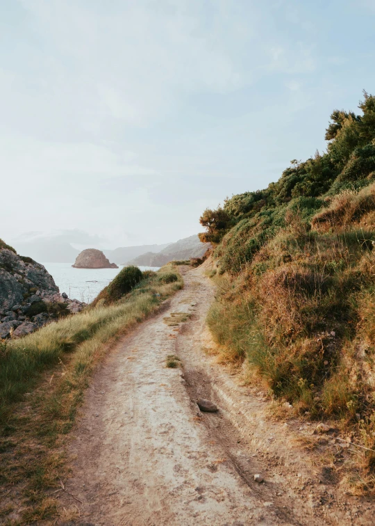 a road leading to a rocky beach and ocean