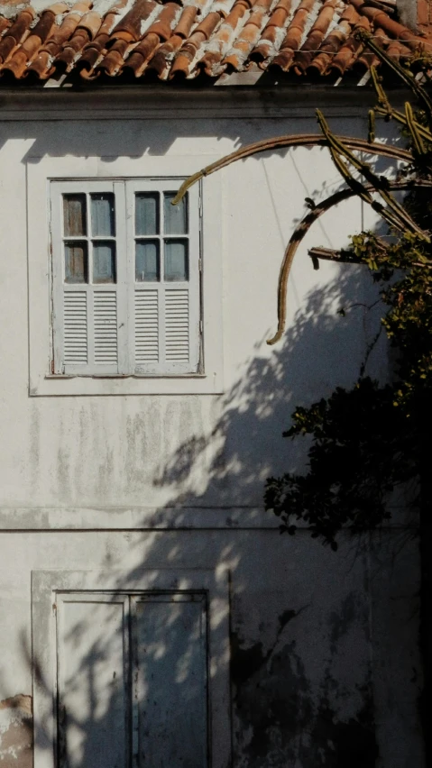 a white building with a closed window on a sunny day