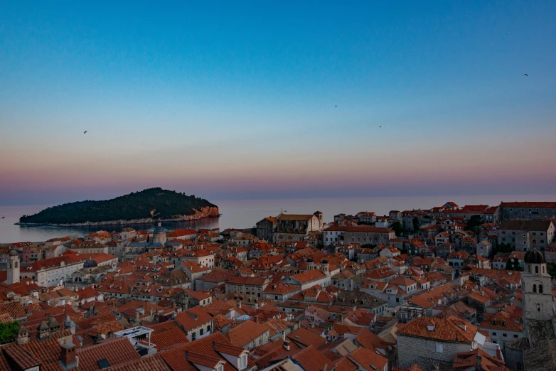 some people and buildings with an ocean in the background