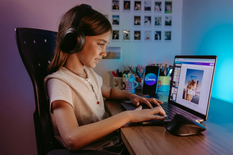 woman wearing headphones is looking at her laptop