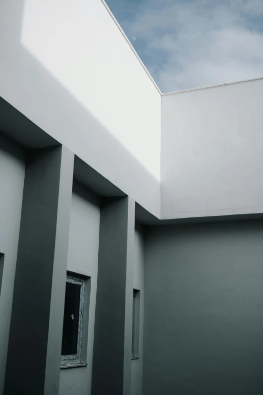 an exterior view of a white building with grey columns