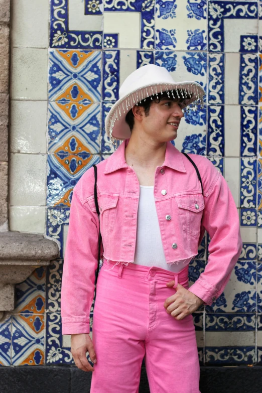 a man wearing a pink suit, white top, and a straw hat