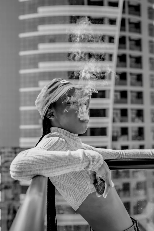 a woman standing against a balcony with her hand on the railing smoking