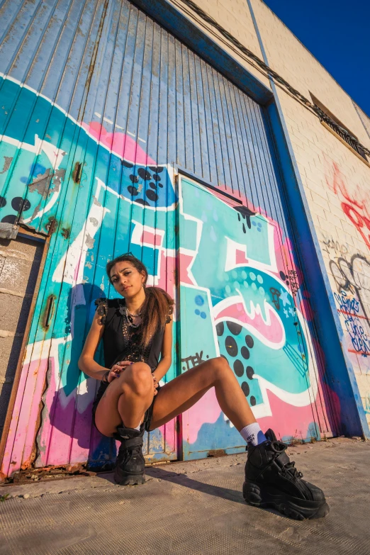 a girl with no panties sitting on a bench in front of graffiti