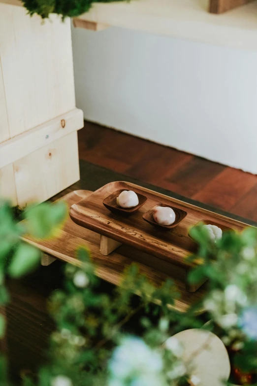 two white eggs are sitting on a wooden tray
