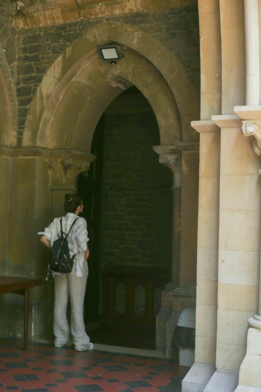 a person with a backpack standing outside a building