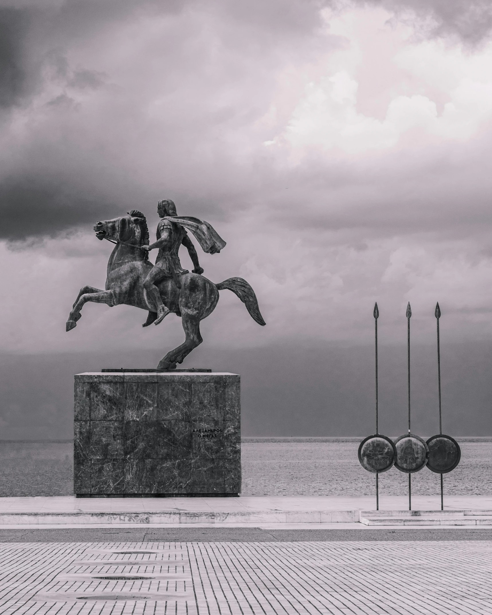 black and white image of an equestrian statue on the street