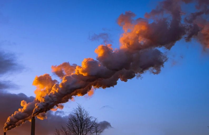 a factory that is releasing out smoke into the sky