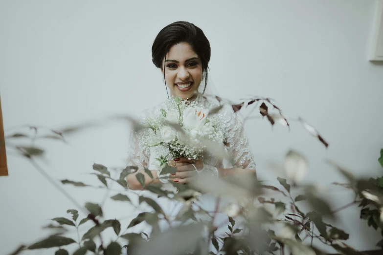 a woman smiling with flowers behind her