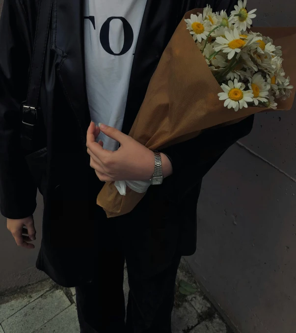 a man standing with a flower bouquet holding it up