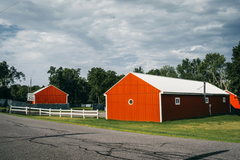 the orange barn is red and white, with a gray roof and windows