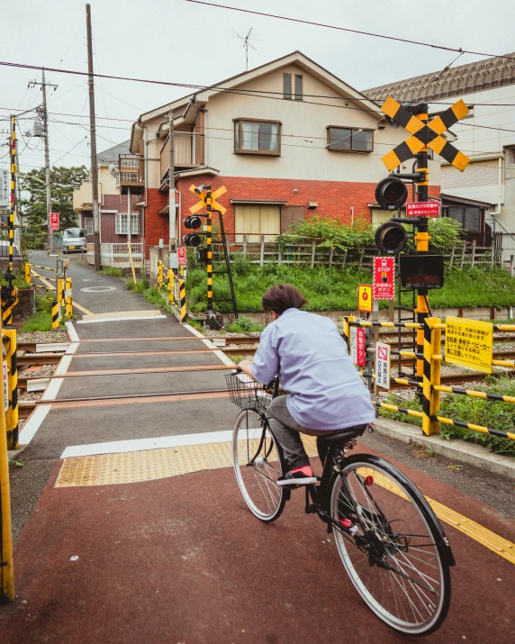 a woman riding her bike down the street next to yellow barriers