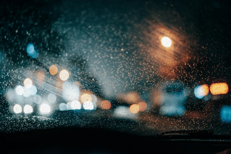 rain is falling on the windshield of a car