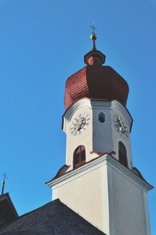 a white tower with a brown top and a clock