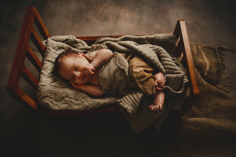 a baby is asleep in a wooden crib, dressed in tan